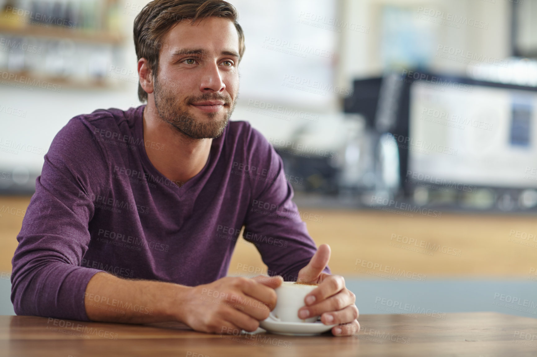 Buy stock photo Shot of a handsome young man looking thoughtful while drinking a cup of coffee at a cafe