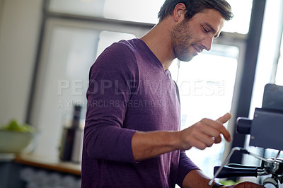 Buy stock photo Shot of a young male barista using an espresso machine in a coffee shop