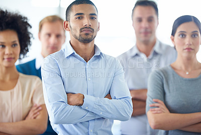Buy stock photo Portrait of a handsome young business man with his colleagues in the background