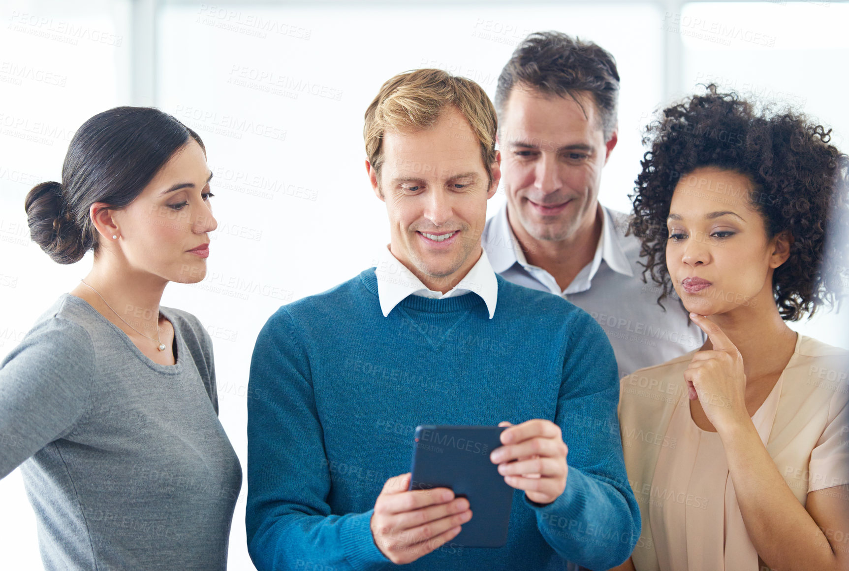 Buy stock photo Shot of a group of colleagues using a digital tablet together