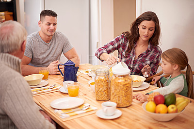 Buy stock photo Home, family and eating breakfast together at table in the morning, hungry and bonding with grandfather. Father, mother and pour milk for kid with cereal, food or nutrition for healthy diet in house