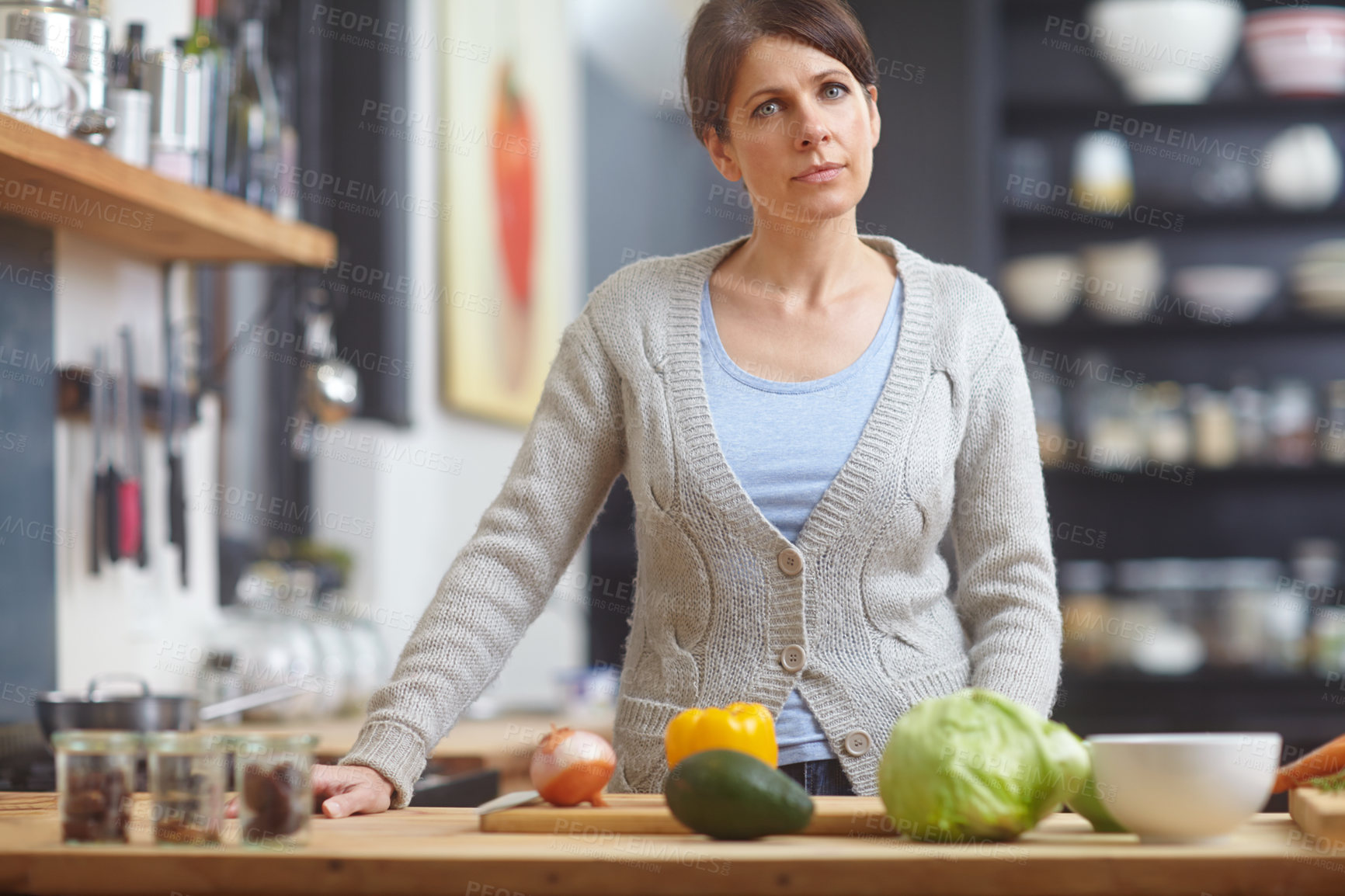 Buy stock photo Portrait of an attractive woman standing behind a kitchen counter filled with vegetables