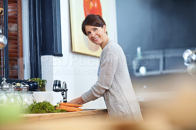 Buy stock photo Shot of an attractive woman washing her hands at the kitchen sink