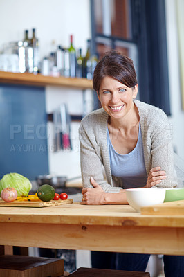 Buy stock photo Portrait of an attractive woman leaning on a kitchen counter filled with vegetables