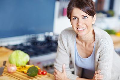 Buy stock photo Portrait of an attractive woman leaning on a kitchen counter filled with vegetables