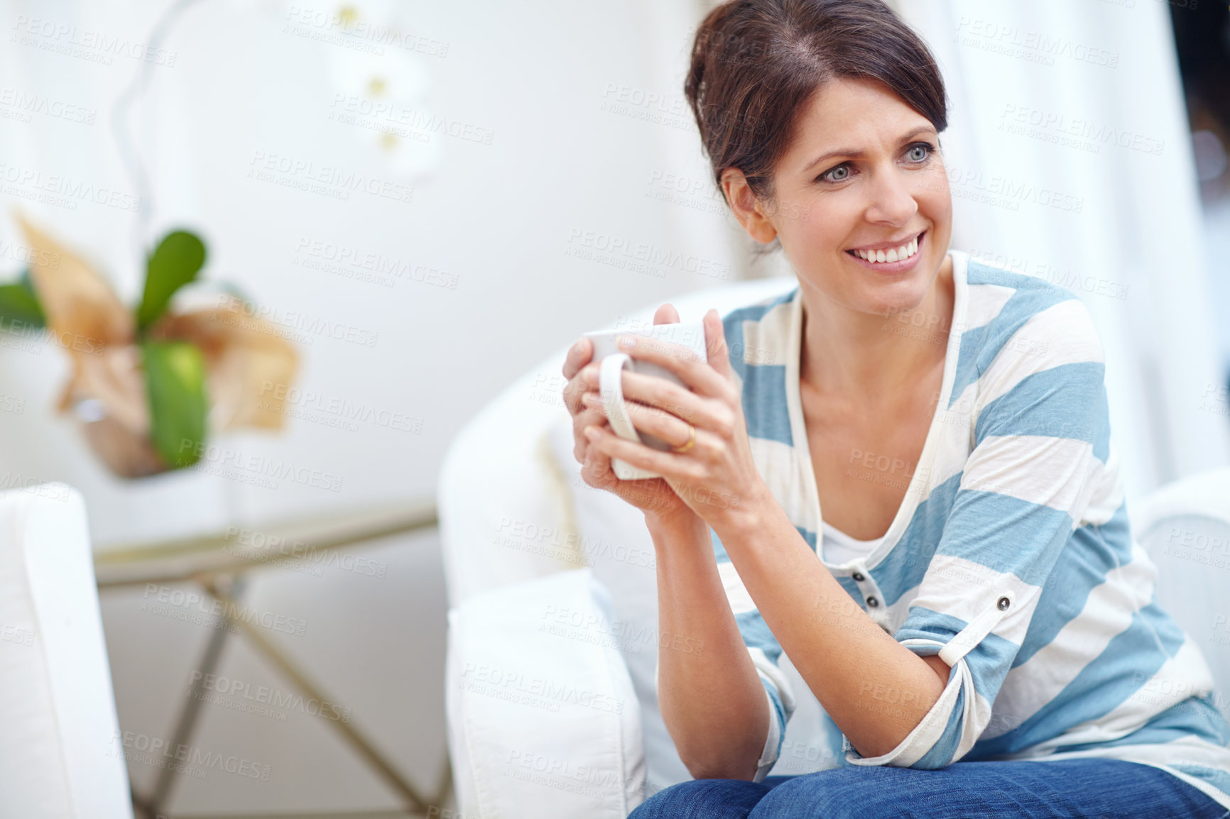 Buy stock photo Shot of a beautiful woman enjoying a cup of coffee at home