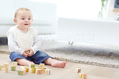 Buy stock photo An adorable little boy wearing casual clothing while playing with his blocks