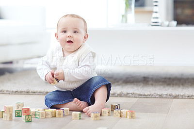 Buy stock photo An adorable little boy wearing casual clothing while playing with his blocks