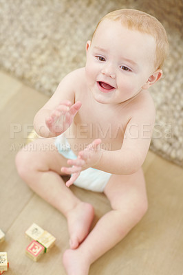 Buy stock photo A cute little boy clapping his hands with his blocks lying next to him