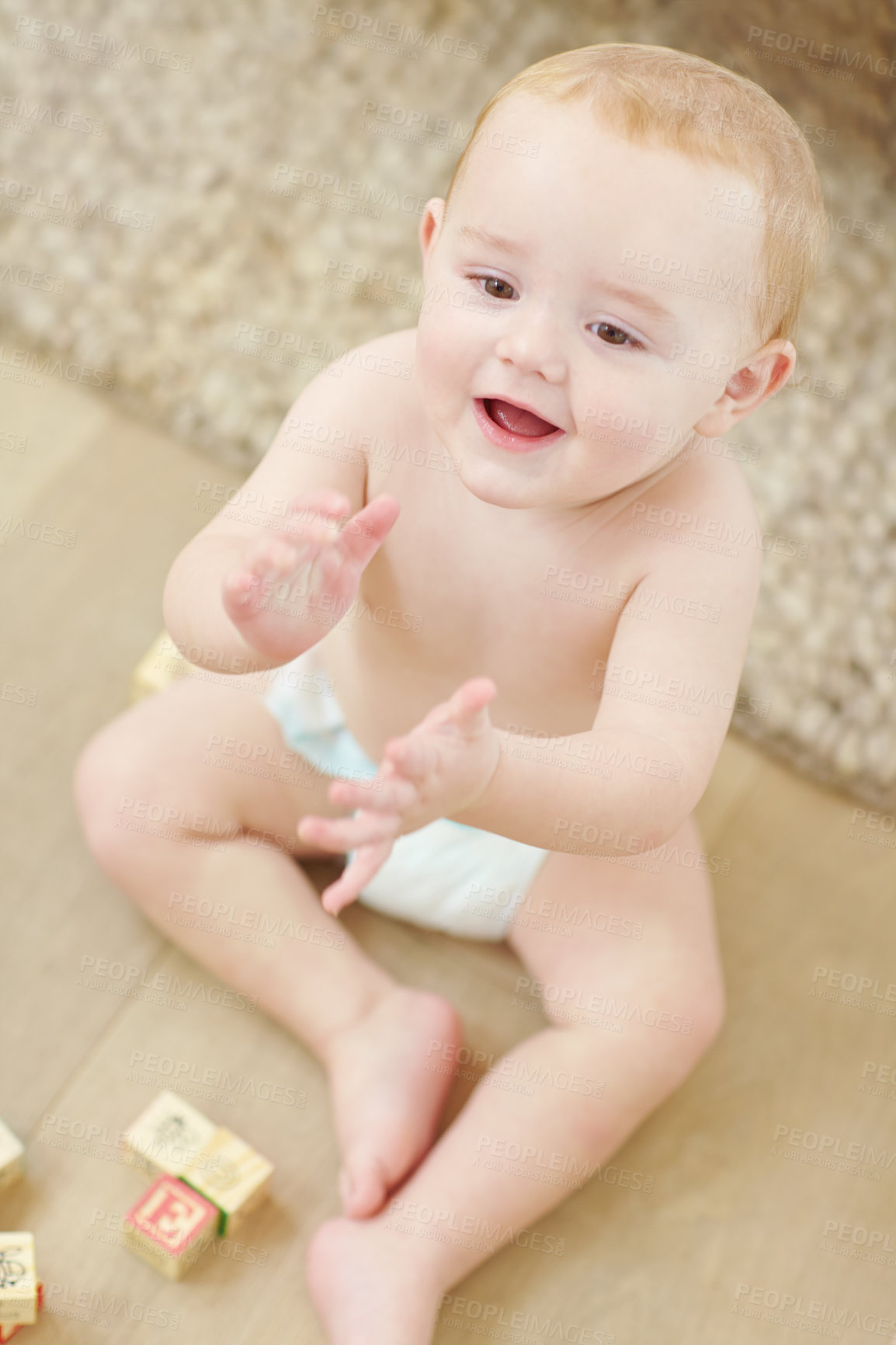 Buy stock photo A cute little boy clapping his hands with his blocks lying next to him