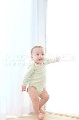 Buy stock photo Shot of an adorable little boy leaning against the window