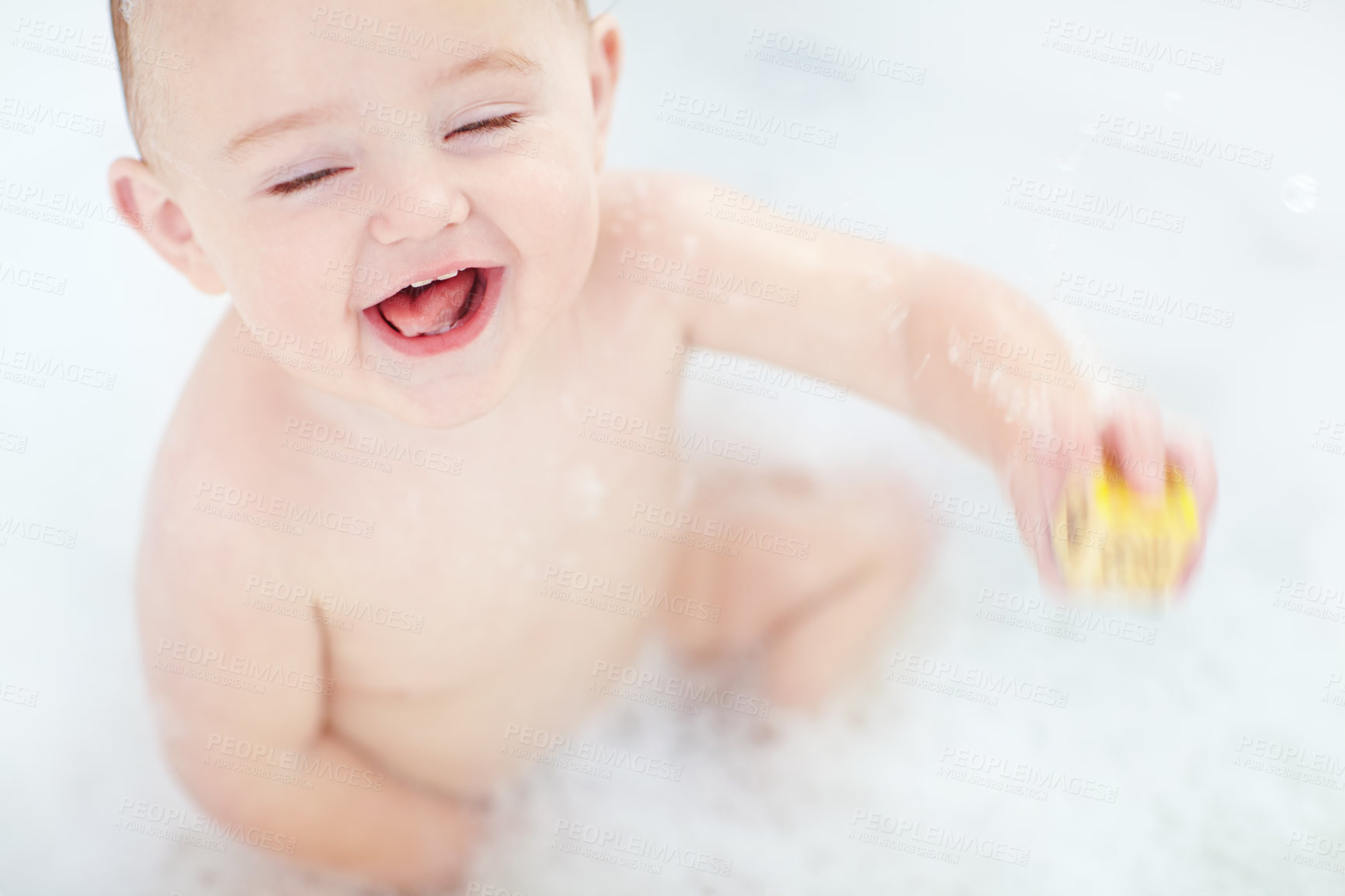 Buy stock photo Shot of an adorable baby boy playing with a toy while bathing