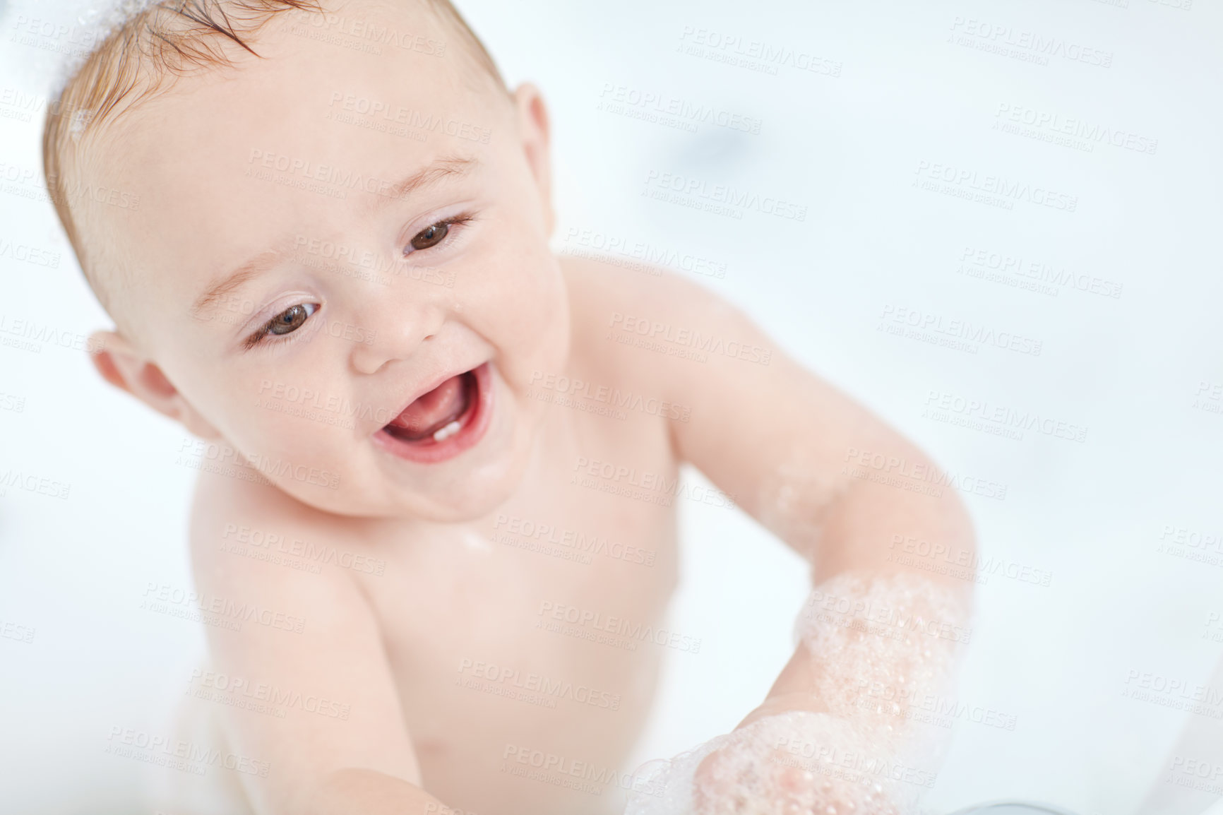 Buy stock photo Shot of a cute baby boy standing in the bathtub