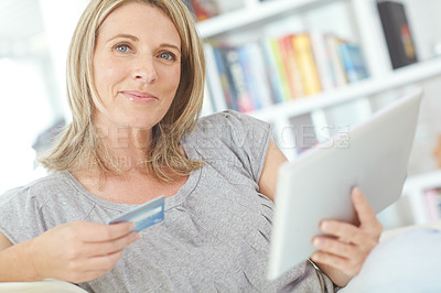 Buy stock photo Portrait of an attractive mature woman holding her credit card while sitting with her tablet