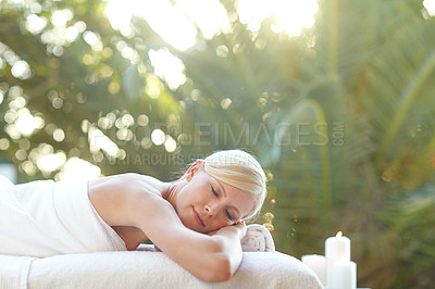 Buy stock photo Shot of a beautiful woman relaxing on a massage table at a spa