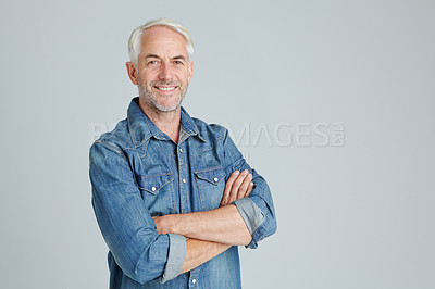 Buy stock photo Studio portrait of a handsome mature man standing with his arms crossed