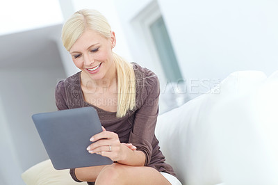 Buy stock photo Shot of a beautiful woman using her digital tablet at home