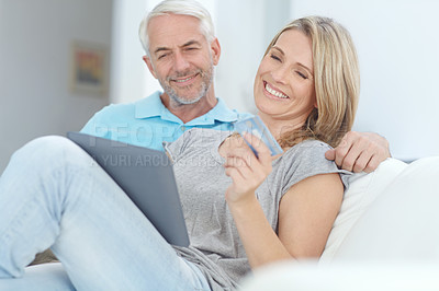 Buy stock photo Mature couple, credit card or tablet banking for financial management, investment security or finance in living room. Smile, happy or relax man or woman on technology for house insurance or home loan