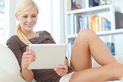 Buy stock photo Shot of a beautiful woman using her digital tablet at home