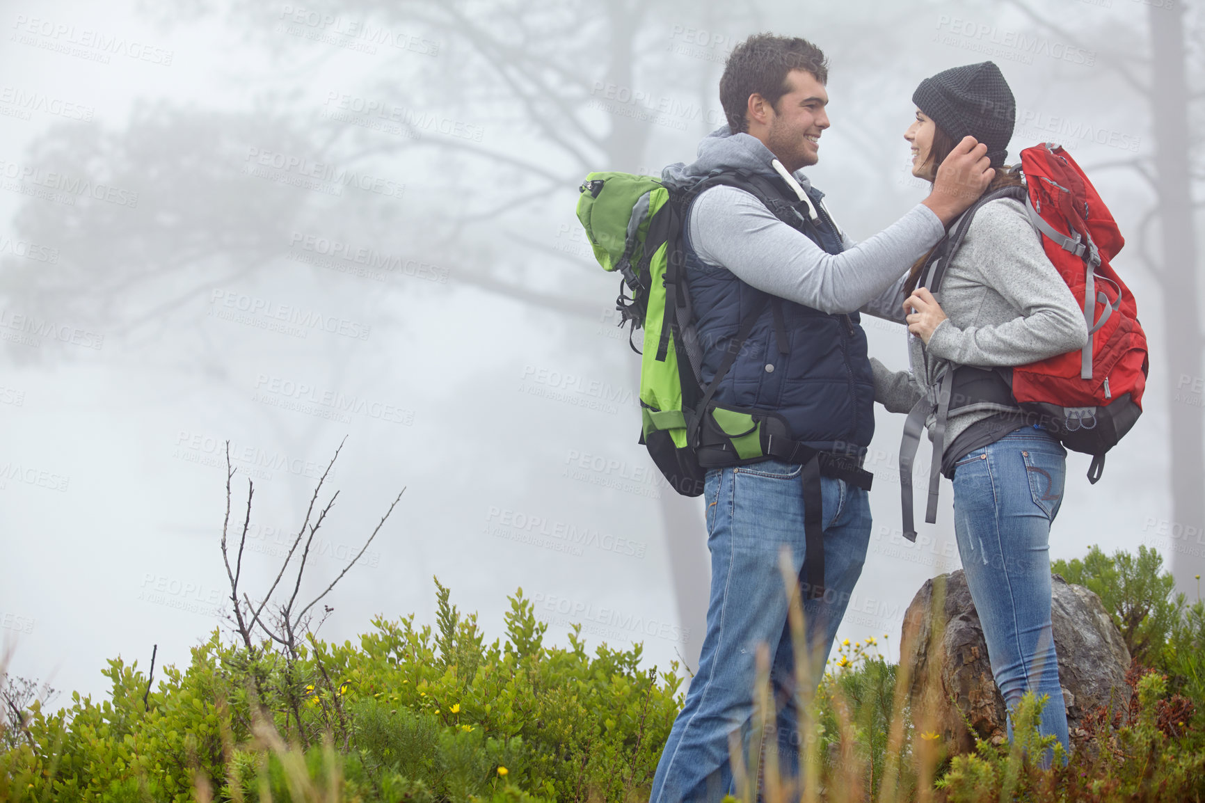 Buy stock photo Shot of a loving young couple being affectionate while on a hike