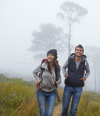 Buy stock photo Shot of a young couple enjoying a hike through nature