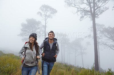 Buy stock photo Shot of a young couple enjoying a hike through nature