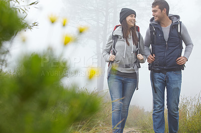 Buy stock photo Shot of a young couple hiking along a nature trail