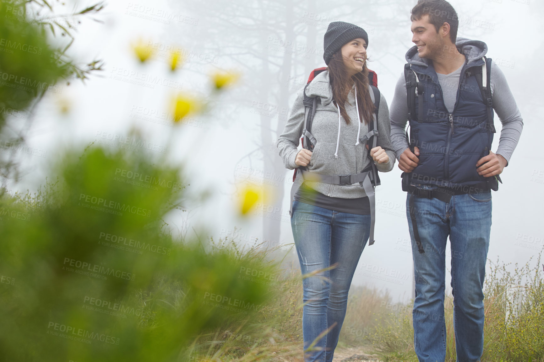 Buy stock photo Shot of a young couple hiking along a nature trail