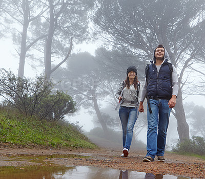 Buy stock photo Full length shot of a young couple hiking through a forest