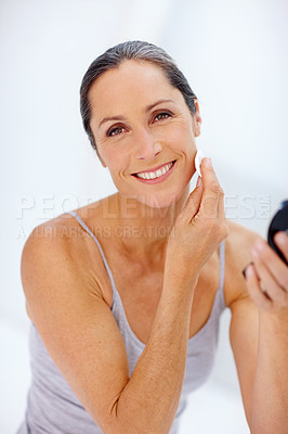 Buy stock photo Shot of an attractive mature woman taking care of her skin