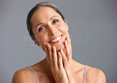 Buy stock photo Studio portrait of a beautiful mature woman posing against a gray background