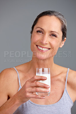 Buy stock photo Happy woman, portrait and milk with glass for calcium, diet or beverage in studio on a gray background. Mature, female person or model with smile or vitamins for diary liquid, digestion or growth