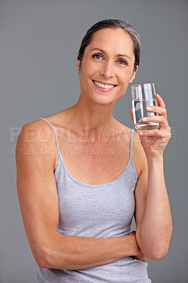 Buy stock photo Happy woman, portrait or water with glass for hydration, diet or beverage in studio on a gray background. Mature, female person or model with smile or vitamins for healthy digestion or mineral liquid