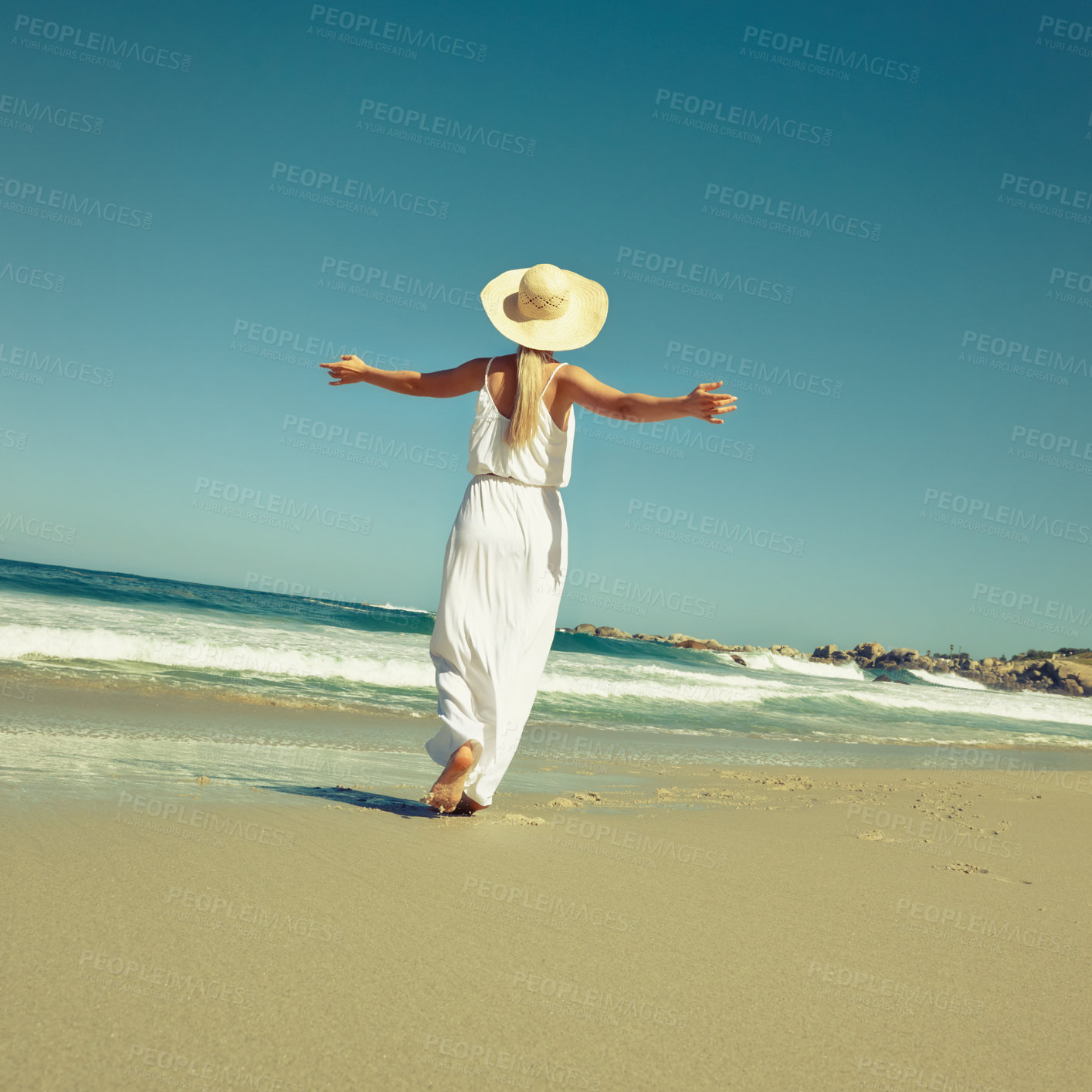Buy stock photo Rearview shot of a woman enjoying a carefree day at the beach