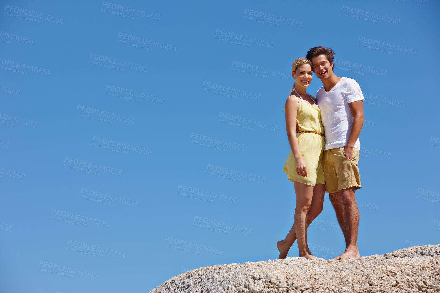 Buy stock photo Blue sky, space or couple on rock with portrait or love on outdoor vacation, valentines day or holiday. Mockup, anniversary or people on boulder for bonding together on romantic date trip in Greece