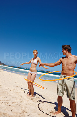 Buy stock photo Couple, plastic ring and beach play by waves together for fun, holiday or bonding with core exercise in nature. Happy people, game and Miami ocean with vacation, adventure and travel with trip