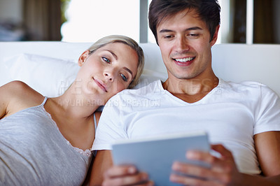 Buy stock photo Couple, happy and tablet on bed for bonding, relax and streaming movie with website, app and video. Man, woman and technology in home for relationship, love and social media with film subscription