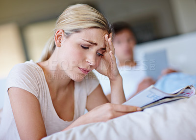 Buy stock photo Home, woman and sad with magazine for reading, information and fight with partner in bedroom. Couple, serious and female person with article for local insight, knowledge and print tips for marriage