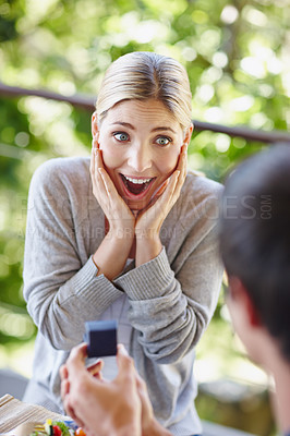 Buy stock photo Shot of a beautiful young woman looking surprisedas her boyfriend is proposing