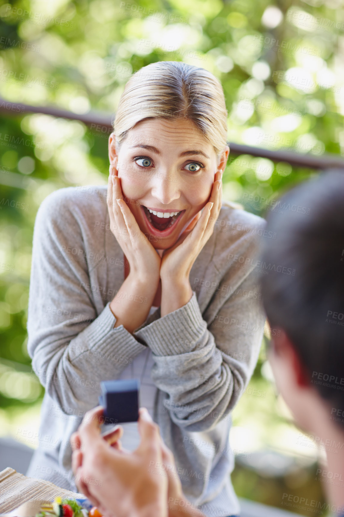 Buy stock photo Shot of a beautiful young woman looking surprisedas her boyfriend is proposing