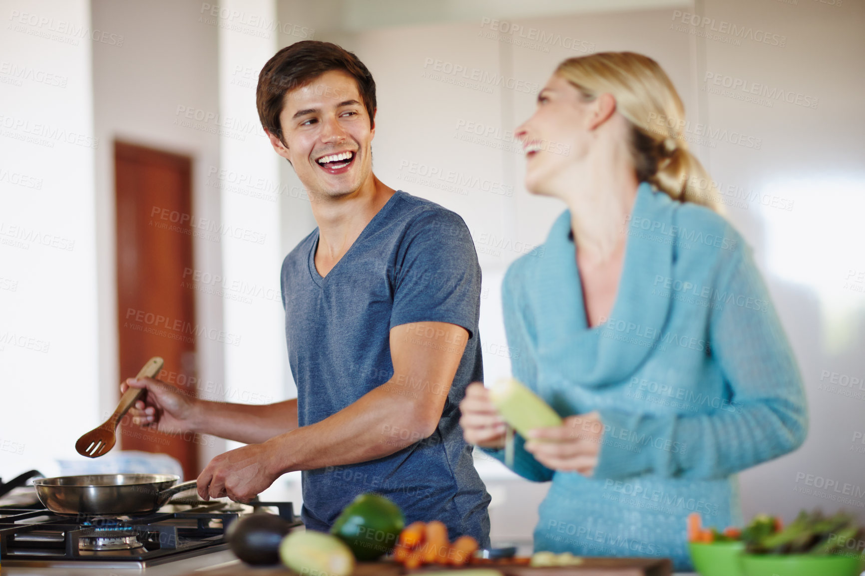 Buy stock photo Shot of a happy young couple cooking a meal together at home