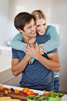 Buy stock photo Shot of a happy young couple sharing an affectionate moment together while preparing a meal