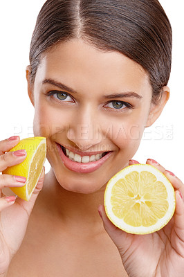 Buy stock photo Studio portrait of a young woman holding up two halves of a lemon