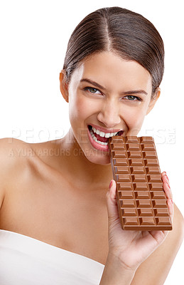 Buy stock photo Studio portrait of an attractive young woman biting into a bar of chocolate