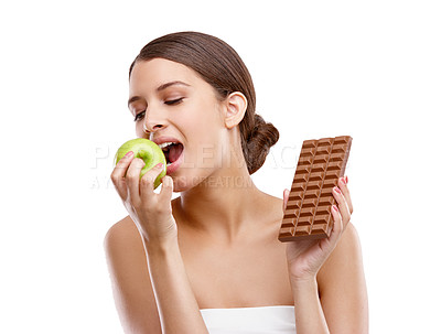 Buy stock photo Apple, bite and chocolate with woman in studio isolated on white background for choice or decision. Diet, health or nutrition and model eating fruit with temptation for cheating or losing weight