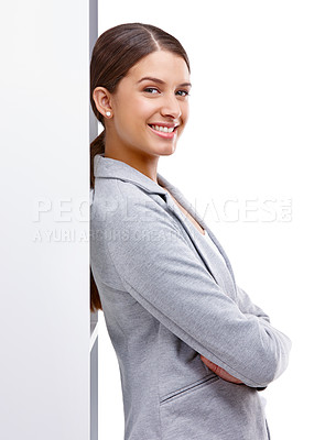 Buy stock photo Studio shot of a confident young woman leaning against a wall 