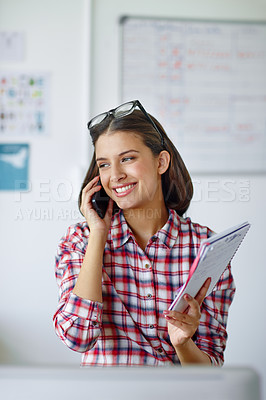 Buy stock photo Shot of a beautiful woman talking on the phone and holding her notebook
