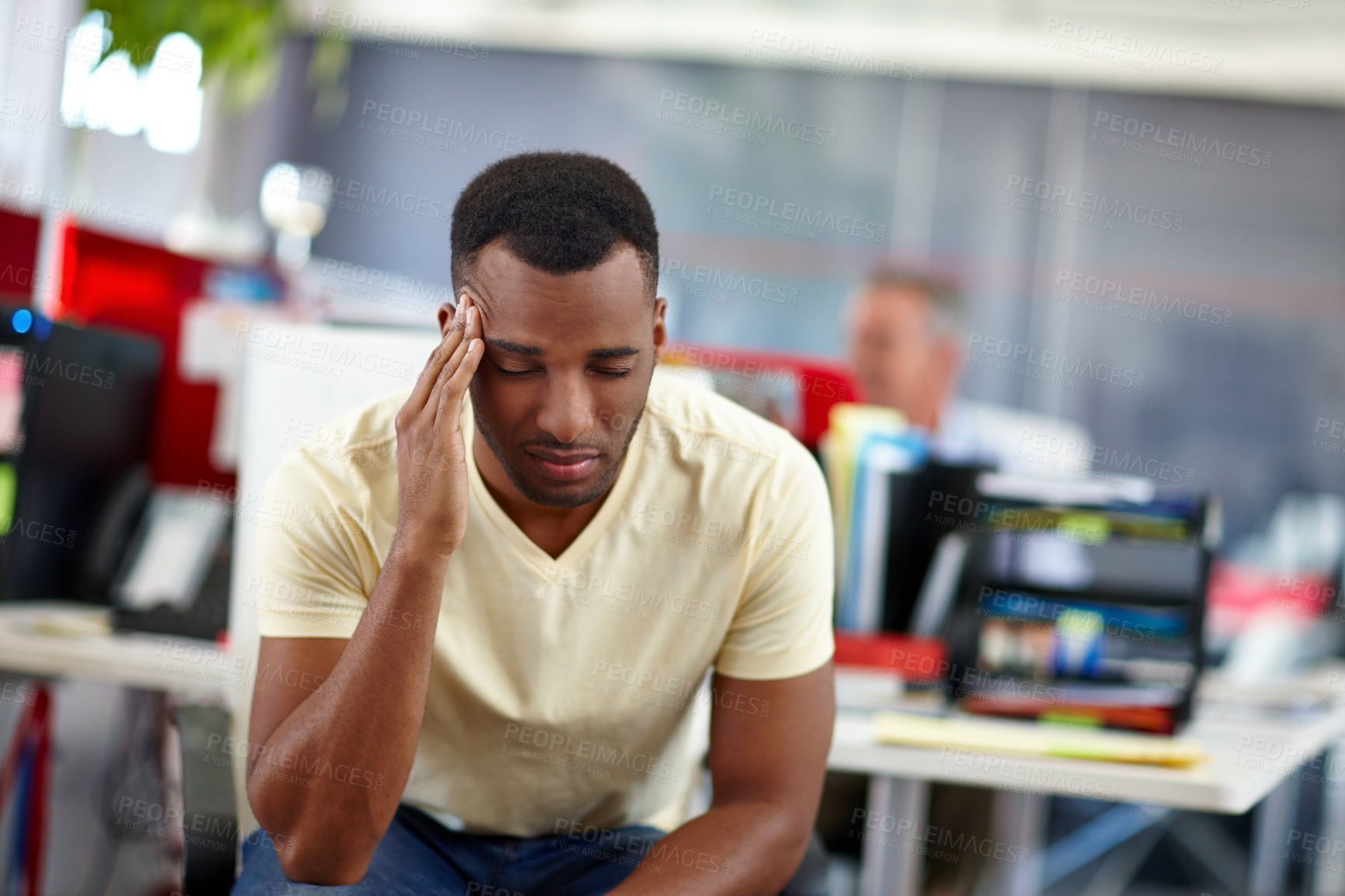 Buy stock photo Shot of a handsome young man suffering from a headache at work