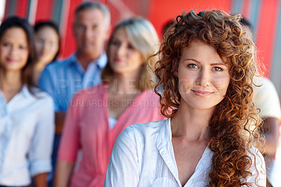 Buy stock photo Shot of a confident young woman standing in front of her colleagues in a casual office environment