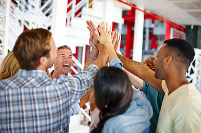 Buy stock photo Shot of a group of coworkers giving each other a high five at the office